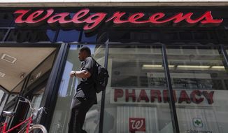 FILE - In this June 25, 2019, file photo a man walks outside a Walgreens pharmacy in downtown Cincinnati. Walgreens is adding the former leader of rival drugstore chain Rite Aid to its executive team. The company said Monday, Aug. 31, 2020, that John Standley will join Walgreens Boots Alliance as president, effective immediately.(AP Photo/John Minchillo, File)