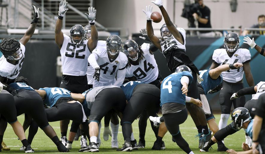 Jacksonville Jaguars defensive players Caraun Reid (92), Josh Allen (41), Dawuane Smoot (94) and Ronnie Harrison (36) trie to block kicker Josh Lambo's (4) field goal attempt during NFL football training camp, Saturday, Aug. 29, 2020, in Jacksonville, Fla. (Bob Self/The Florida Times-Union via AP)