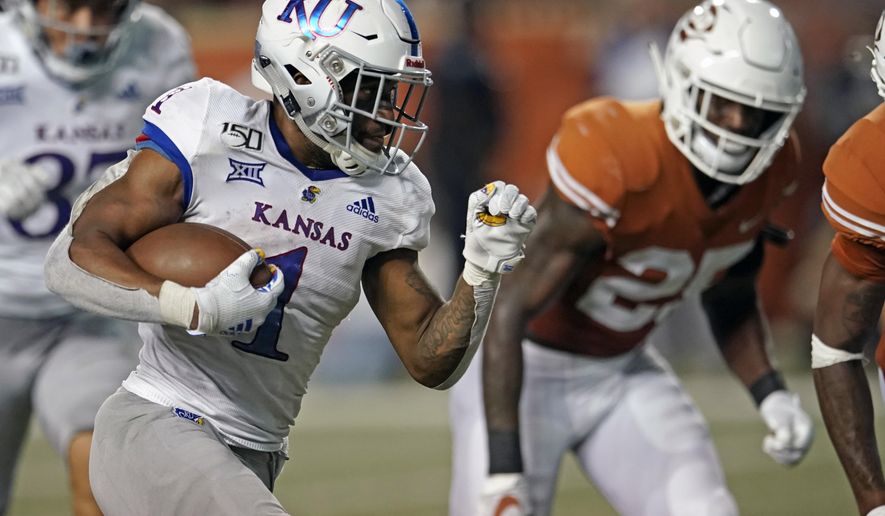 FILE - In this Oct. 19, 2019, file photo, Kansas' Pooka Williams Jr. (1) runs for a touchdown against Texas during the second half of an NCAA college football game in Austin, Texas. With some returning talent on both sides of the ball and continuity among his staff, Kansas coach Les Miles is confident that more progress will be made this season. (AP Photo/Chuck Burton, File)