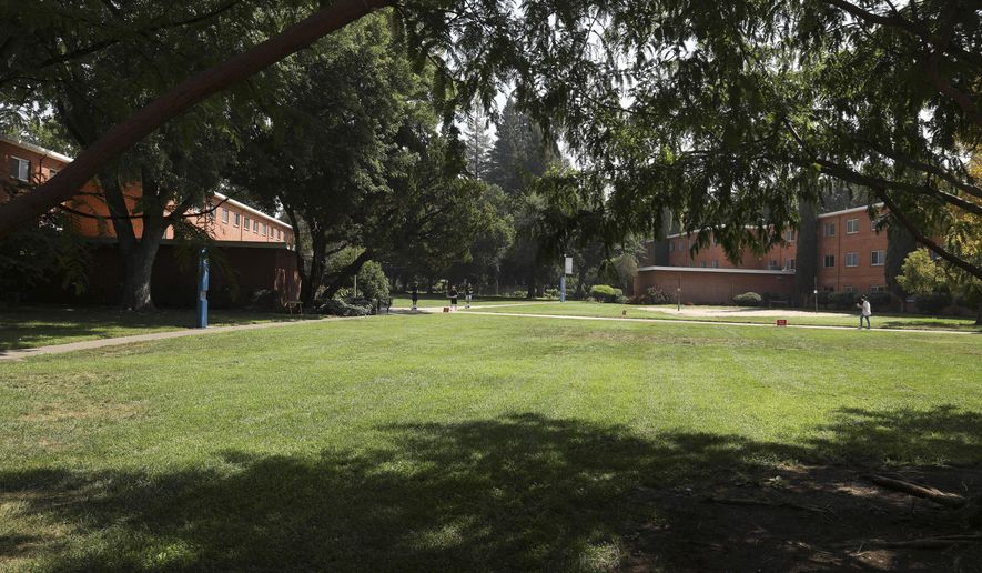 FILE - In this Aug. 31, 2020, file photo, people walk on the campus at California State University, Chico, in Chico, Calif. California State University, Chico said Tuesday, Sept. 1, 2020, it has no access to coronavirus test kits, despite requesting them for months, so is unable to screen for the virus on campus amid an outbreak that prompted it to abruptly halt in-person classes earlier in the week. (Carin Dorghalli/The Chico Enterprise-Record via AP, File)