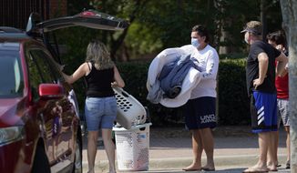 Students and parents begin to move student&#39;s belongings out of Bragaw Hall at N.C. State University in Raleigh, N.C., Thursday, Aug. 27, 2020. Thursday is the first day students will begin moving out of campus housing due to continuing spread of COVID-19 clusters around campus. (AP Photo/Gerry Broome)