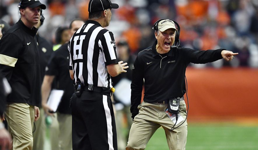 FILE - In this Saturday, Nov. 30, 2019, file photo, Wake Forest head coach Dave Clawson, right, speaks to an official during the second half of an NCAA college football game against Syracuse in Syracuse, N.Y. Wake Forest has been to four straight bowl games but will have to overcome significant personnel losses on offense in Clawson's seventh season. (AP Photo/Adrian Kraus, File)