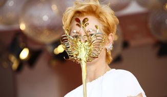 Actress Tilda Swinton holds a carnival mask as she poses for photographers upon arrival at the opening ceremony of the 77th edition of the Venice Film Festival in Venice, Italy, Wednesday, Sept. 2, 2020. (Photo by Joel C Ryan/Invision/AP)