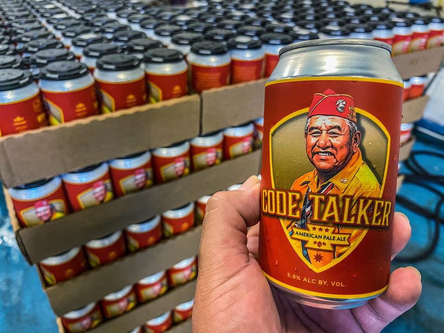 In this Aug. 14, 2020, photo courtesy of LT Goodluck, LT Goodluck holds a beer can honoring his grandfather, Navajo Code Talker John V. Goodluck at the Hellbender Brewing Co., in Washington, D.C. In honor of National Navajo Code Talkers Day the craft brewery recently rereleased its Code Talker American Pale Ale , this time in a can, drawing some rave reviews but also backlash. The beer was formulated and brewed by Goodluck in honor of his late grandfather and Navajo Code Talker John V. Goodluck. (LT Goodluck via AP)
