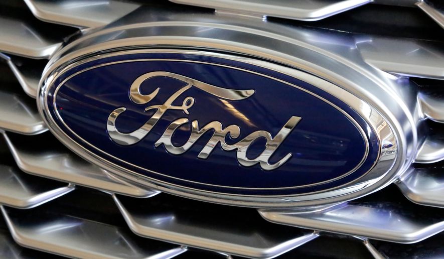 FILE- This Feb. 15, 2018, file photo shows a Ford logo on the grill of a 2018 Ford Explorer on display at the Pittsburgh Auto Show.  Ford Motor Co. will offer early retirement incentives with hopes of cutting its U.S. white-collar workforce by 1,400 more positions. President for the Americas Kumar Galhotra told employees about the offers Wednesday, Sept. 2, 2020.   (AP Photo/Gene J. Puskar, File)