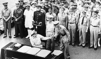 FILE - In this Sept. 2, 1945, file photo, U.S. General Douglas MacArthur hands the pen to British Lieut. Gen. Arthur E. Percival after signing surrender papers aboard the battleship USS Missouri in Tokyo Bay. Wednesday, Sept. 2, 2020, is the anniversary of the formal Sept. 2, 1945, surrender of Japan to the United States. (Pool Photo via AP, File)