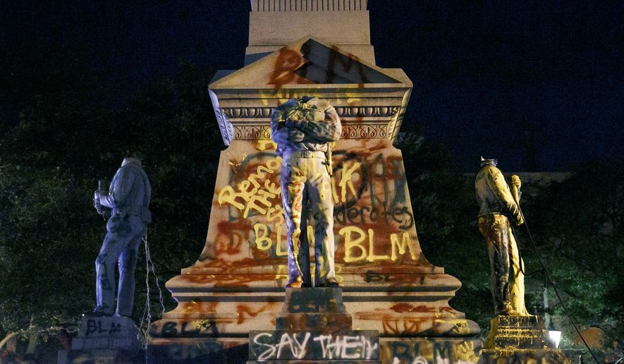 File-The statues on the Confederate monument are covered in graffiti and beheaded after a protest in Portsmouth, Va., Wednesday, June 10, 2020. Protesters beheaded and then pulled down four statues that were part of a Confederate monument. When protesters gathered at one of Virginia’s Confederate monuments in June, police say a state senator approached them with a warning: “(T)hey are going to put some paint on this thing, and y’all can’t arrest them.” Sen. Louise Lucas, 76, a Black woman and high-ranking Democratic power broker, stood near the 56-foot (17-meter) memorial in the city of Portsmouth. Police said she was with a group of people shaking up cans of spray paint. (Kristen Zeis/The Virginian-Pilot via AP, File)