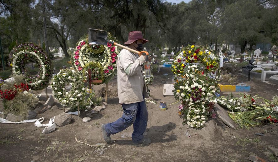 A grave digger walks in the COVID-19 section of the cemetery of San Lorenzo Tezonco Iztapalapa on the outskirts of Mexico City, Tuesday, Sept. 1, 2020. (AP Photo/Marco Ugarte)