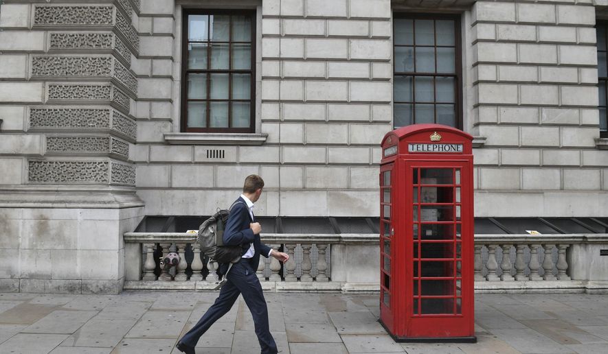 A man walks past the Department for Digital, Culture, Media and Sport in London's Whitehall, around the old normal morning time 'rush hour', in central London, Thursday Sept. 3, 2020. Workers are being encouraged to return to their offices, with a Government information campaign reminding people about the efforts taken to make workplaces safe and "Covid-secure". (Victoria Jones/PA via AP)