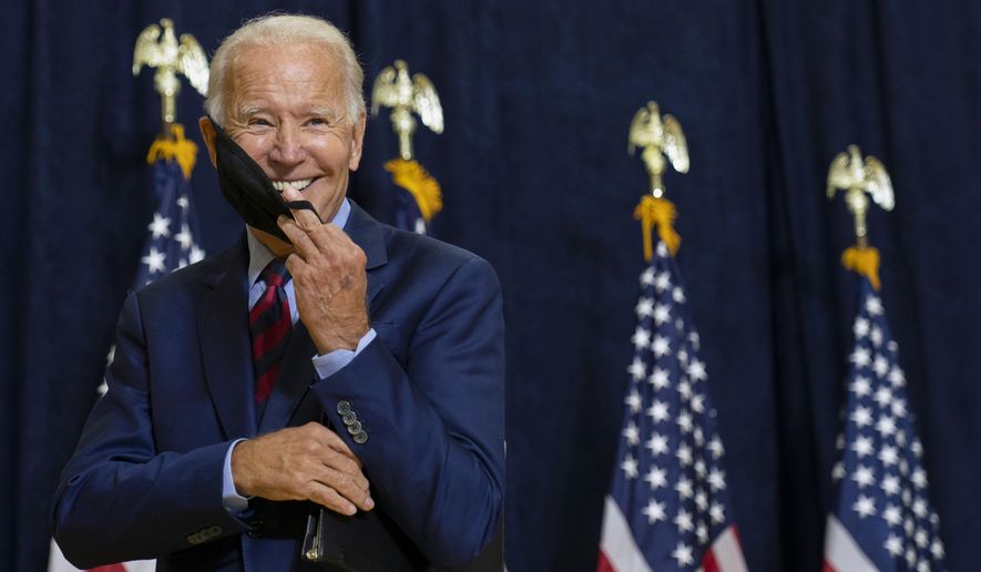 Democratic presidential candidate former Vice President Joe Biden smiles as he puts on his face mask after speaking to media in Wilmington, Del., Friday Sept. 4, 2020. (AP Photo/Carolyn Kaster)