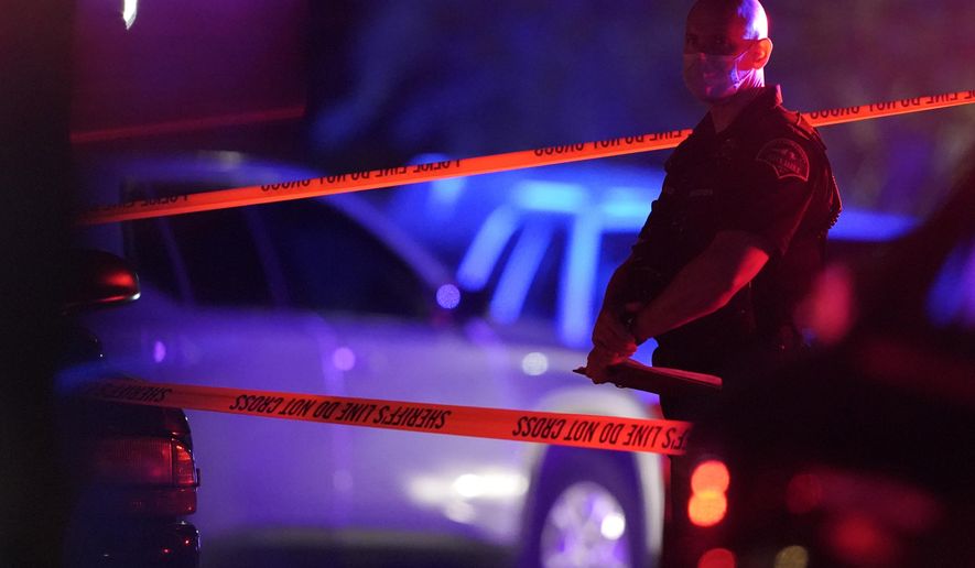 A Thurston County Sheriff's Deputy wears a mask as he stands near crime scene tape, Thursday, Sept. 3, 2020, in Lacey, Wash. at the scene where Michael Reinoehl was killed Thursday night as investigators moved in to arrest him. Reinoehl had been suspected of fatally shooting a supporter of a right-wing group in Portland, Oregon, last week after a caravan of Donald Trump backers rode through downtown Portland. (AP Photo/Ted S. Warren)