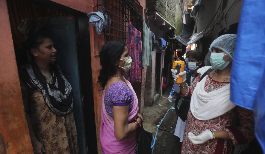 A health worker screens people for symptoms of COVID-19 in Dharavi, one of Asia's biggest slums, in Mumbai, India, Friday, Sept. 4, 2020. The number of people infected with the coronavirus in India rose by another 80,000 and is near Brazil's total, the second-highest in the world. (AP Photo/Rafiq Maqbool)