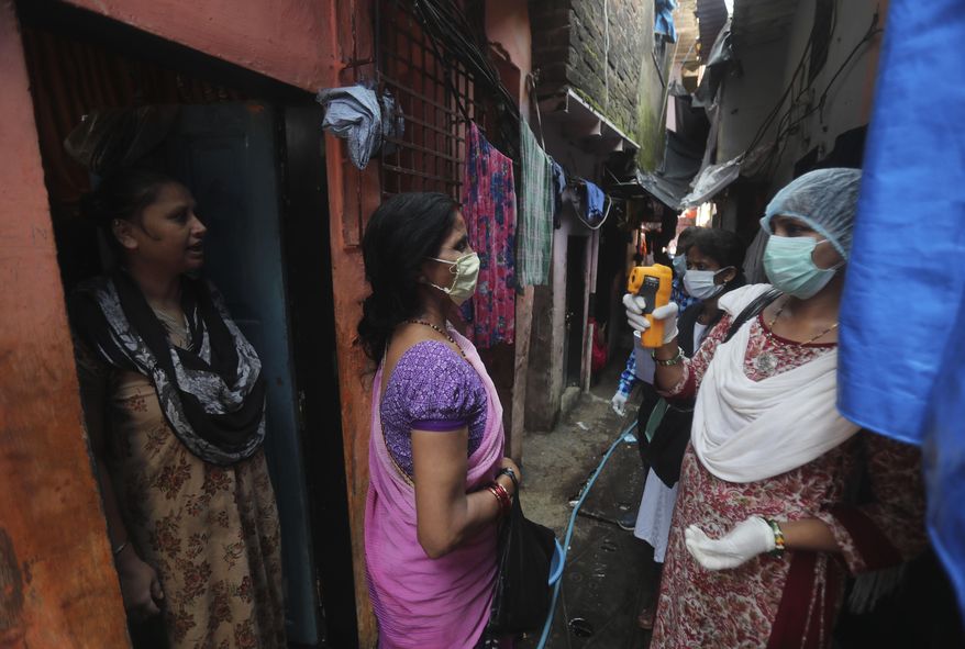 A health worker screens people for symptoms of COVID-19 in Dharavi, one of Asia's biggest slums, in Mumbai, India, Friday, Sept. 4, 2020. The number of people infected with the coronavirus in India rose by another 80,000 and is near Brazil's total, the second-highest in the world. (AP Photo/Rafiq Maqbool)