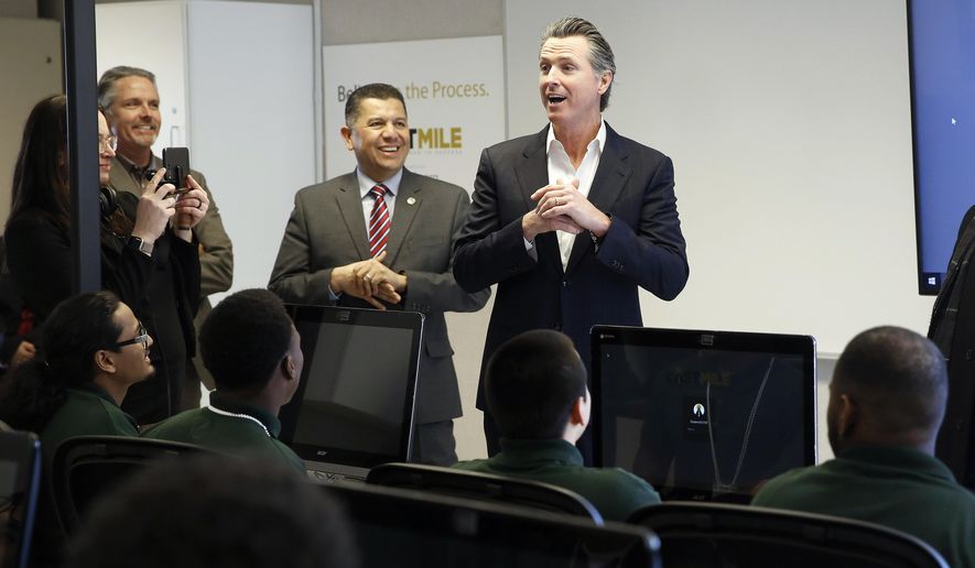 FILE - In this Jan. 22, 2019 file photo, Gov. Gavin Newsom, right, addresses youthful offenders taking a computer coding class at the O.H. Close Youth Correctional Facility in Stockton, Calif. Newsom is now considering legislation sent to him by lawmakers that would phase out the state-operated juvenile prison system, create an Office of Youth and Community Restoration and send grants to counties to provide custody and supervision of the most violent criminal youths. (AP Photo/Rich Pedroncelli, File)