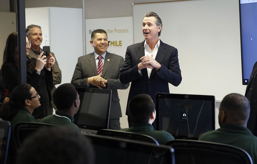 FILE - In this Jan. 22, 2019 file photo, Gov. Gavin Newsom, right, addresses youthful offenders taking a computer coding class at the O.H. Close Youth Correctional Facility in Stockton, Calif. Newsom is now considering legislation sent to him by lawmakers that would phase out the state-operated juvenile prison system, create an Office of Youth and Community Restoration and send grants to counties to provide custody and supervision of the most violent criminal youths. (AP Photo/Rich Pedroncelli, File)