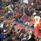 FILE - Fans reach out to high-five pole-sitter Chase Elliott during driver introductions for the NASCAR Sprint Cup auto race at Daytona International Speedway, Saturday, July 7, 2018, in Daytona Beach, Fla. NASCAR has built itself around its traveling show, every weekend a super-charged event of concerts, camping and infield carousing that closes with a Cup race. The party has been canceled during the pandemic but the playoffs go on, starting Sunday, Sept. 6, 2020, without any of the pomp and circumstance. (AP Photo/John Raoux, File)