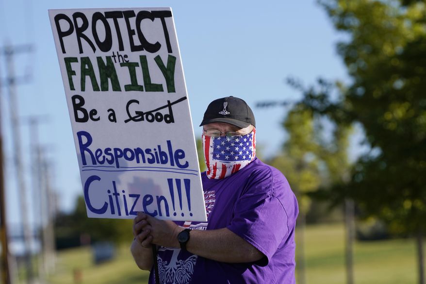 Law enforcement supporters protest during a Back the Blue rally Thursday, Sept. 3, 2020, in West Valley City, Utah. After months of protests around the nation over racial injustice in policing, police groups in Utah say they have grown frustrated with rhetoric they describe as unfair and called for The Salt Lake Tribune to apologize after it published an editorial cartoon linking the Ku Klux Klan with law enforcement. (AP Photo/Rick Bowmer)