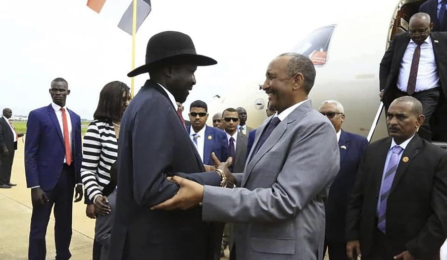 FILE - In this Oct. 14, 2019 file photo, provided by the official SUNA news agency, Gen. Abdel-Fattah Burhan, center right, head of Sudan&#39;s sovereign council, is greeted by South Sudan&#39;s President Salva Kiir, center left, as Sudan&#39;s new transitional government kicks off peace talks aimed at ending the country&#39;s yearslong civil wars, in Juba, South Sudan. The Sudan Revolutionary Front, a rebel alliance, and Sudan’s transitional authorities signed a peace deal Monday, Aug. 31, 2020, following months of negotiations in Juba. But other powerful armed groups have thus far declined to join them. (SUNA via AP, File)