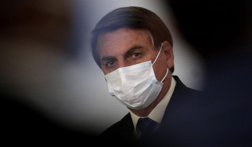 Brazil&#39;s President Jair Bolsonaro wearing a mask attends a ceremony about the extension of emergency aid to help the poor population affected by the COVID-19 pandemic, at the Planalto Presidential Palace, in Brasilia, Brazil, Tuesday, Sept. 1, 2020. (AP Photo/Eraldo Peres)