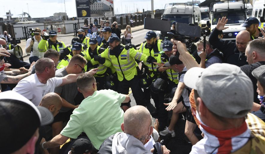Anti-migrant protesters react with police, in Dover, England, Saturday, Sept. 5, 2020. Police controlled a small scale demonstration against immigration, calling for authorities to do more to protect English shores, at England's southern port city nearest to mainland Europe. (Stefan Rousseau/PAvia AP)