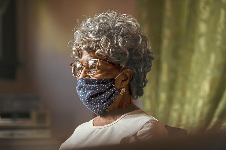 This Aug. 4, 2020 photo shows Nan Currington, 104, at her home in Pittsburgh. Currington always sits in the front pew of the Mount Hope Presbyterian Church in Penn Hills. Mount Hope reopened for in-person service on July 5, but Currington hasn’t returned to her pew just yet. She’s been keeping up by watching the church’s Facebook live streams of the sermons on her computer. (Steve Mellon/Pittsburgh Post-Gazette via AP)
