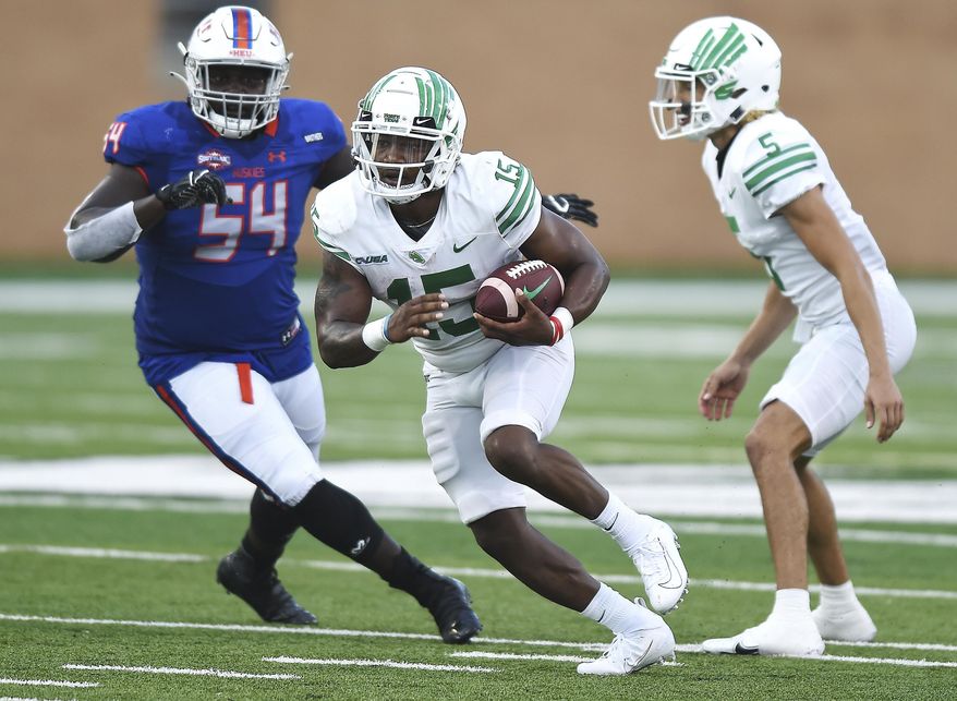 North Texas' Tre Siggers (15) takes the handoff from Jason Bean (5) during the first half against Houston Baptist in an NCAA college football game Saturday, Sept. 5, 2020, in Denton, Texas. (Al Key/The Denton Record-Chronicle via AP)