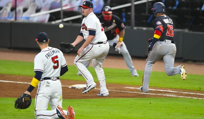 Atlanta Braves relief pitcher Tyler Matzek, center, cannot get a glove on a toss from first baseman Freddie Freeman (5) as Washington Nationals&#x27; Victor Robles (16) runs safely to first on a one-run bunt during the sixth inning of a baseball game Saturday, Sept. 5, 2020, in Atlanta. (AP Photo/John Amis)