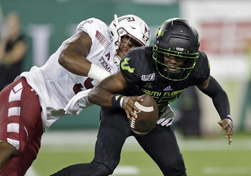 FILE - This Nov. 7, 2019, file photo shows Temple defensive end Quincy Roche trying to sack South Florida quarterback Jordan McCloud during the first half of an NCAA college football game in Tampa, Fla. While most of the offseason chatter surrounding college football transfers inevitably focuses on quarterbacks, plenty of notable players at other positions also switched teams and could make major impacts for their new schools this fall. Roche, the American Athletic Conference defensive player of the year last season, transferred to Miami. (AP Photo/Chris O'Meara, File)