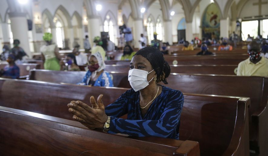 A churchgoer wears a face mask and practices social distancing to curb the spread of the coronavirus during a Sunday mass at the Holy Cross Cathedral in Lagos, Nigeria, on Sunday, Aug. 30, 2020. The COVID-19 pandemic is testing the patience of some religious leaders across Africa who worry they will lose followers, and funding, as restrictions on gatherings continue. (AP Photo/Sunday Alamba) **FILE**