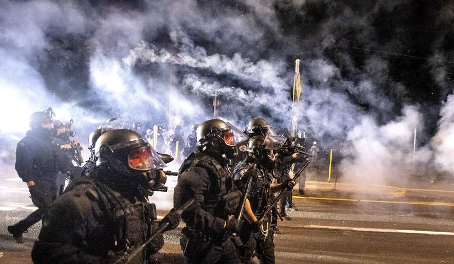 Police use chemical irritants and crowd control munitions to disperse protesters during the 100th consecutive day of demonstrations in Portland, Ore.,  on Saturday, Sept. 5, 2020. According to an officer, police responded with stronger tactics after a molotov cocktail was thrown.(AP Photo/Noah Berger)