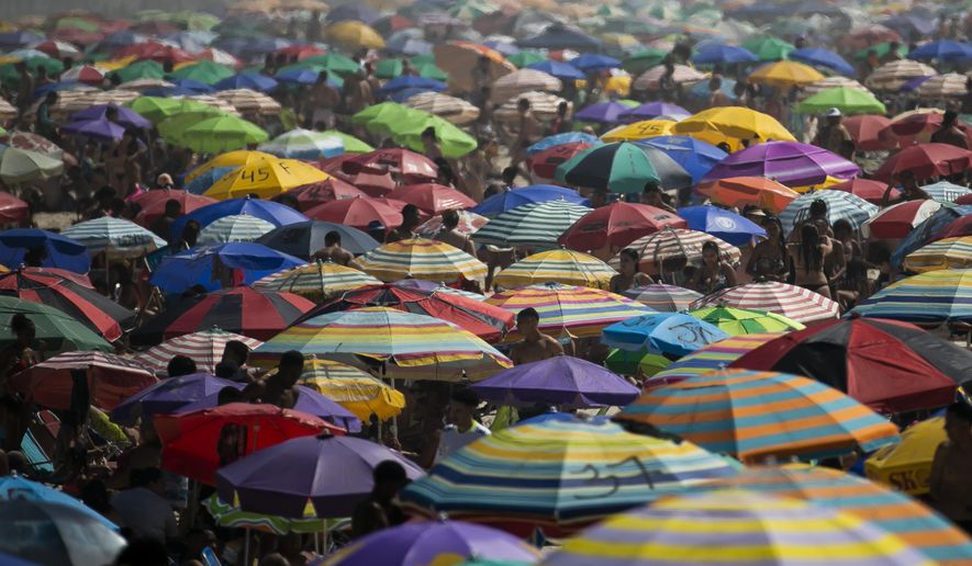 People enjoy the Ipanema beach amid the new coronavirus pandemic in Rio de Janeiro, Brazil, Sunday, Sept.6, 2020. Brazilians are packing the beaches and bars this weekend, taking advantage of a long holiday to indulge in normal life even as the COVID-19 pandemic rages on. (AP Photo/Bruna Prado)