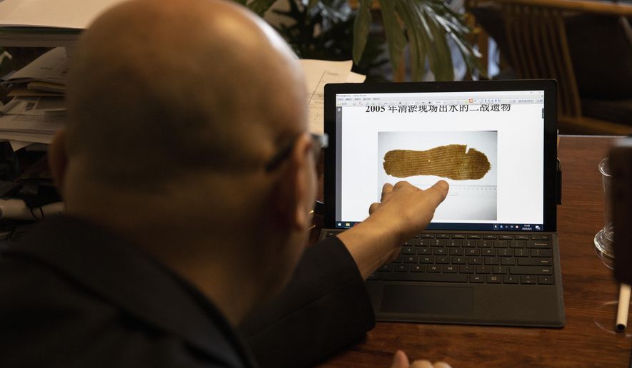 Han Bo, chairman of the China Adventure Association, talks about an insole found during an exploratory dive at the crash site of a fighter plane from the legendary Flying Tigers group of American pilots that crashed in a lake during World War II at his office in Beijing on Saturday, Sept. 5, 2020. The Flying Tigers, who were sent to China in 1941 by President Franklin D. Roosevelt before Washington joined the war, have long been one of the most potent symbols of U.S.-Chinese cooperation. The Tigers fought Japanese invaders from December 1941 until they were absorbed into the U.S. military the following July. (AP Photo/Ng Han Guan)