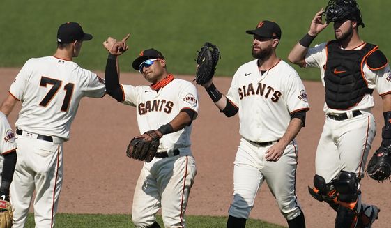 San Francisco Giants&#39; Tyler Rogers, from left, celebrates with Donovan Solano, Brandon Belt and Joey Bart after the Giants defeated the Arizona Diamondbacks in a baseball game in San Francisco, Sunday, Sept. 6, 2020. (AP Photo/Jeff Chiu)