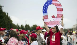 FILE - In this Aug. 2, 2018, file photo, a protesters holds a Q sign waits in line with others to enter a campaign rally with President Donald Trump in Wilkes-Barre, Pa. Candidates engaging with the QAnon conspiracy theory are running for seats in state legislatures this year, breathing more oxygen into a once-obscure conspiracy movement that has grown in prominence since adherents won Republican congressional primaries this year. (AP Photo/Matt Rourke, File)