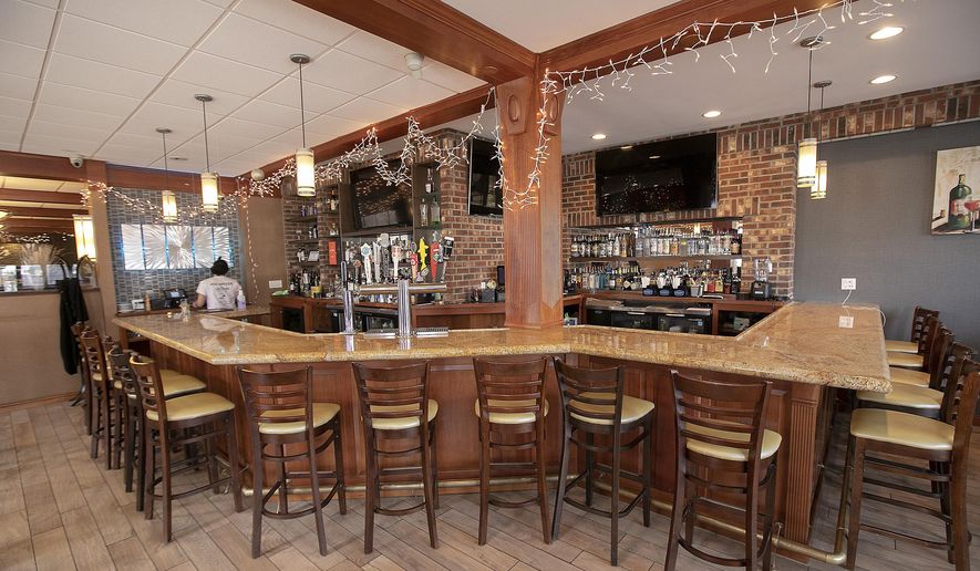 FILE - In this March 16, 2020 file photo, the bar area is empty at Flair Restaurant and Bar as the business offers curbside pick up during the coronavirus pandemic in Southington, Conn. When a large swath of Connecticut was forced to shut down during the early days of the pandemic, state officials created an emergency loan program from scratch, hoping to help small businesses weather the economic crisis. Months later, records obtained by The Associated Press through a Freedom of Information Act request show the fledgling Connecticut Recovery Bridge Loan Program ultimately funded 2,123 one-year, no-interest loans, averaging $19,705 a piece. Because of the massive flood of applications, officials decided to cap loan amounts at $37,500 — half of the $75,000 originally promised when the program was launched in March — to help twice the number of businesses. (Dave Zajac/Record-Journal via AP, File)