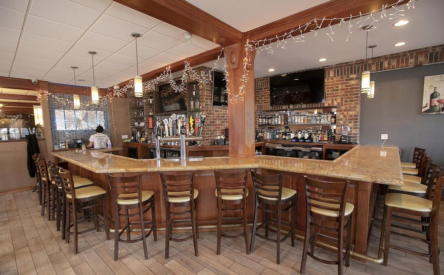 FILE - In this March 16, 2020 file photo, the bar area is empty at Flair Restaurant and Bar as the business offers curbside pick up during the coronavirus pandemic in Southington, Conn. When a large swath of Connecticut was forced to shut down during the early days of the pandemic, state officials created an emergency loan program from scratch, hoping to help small businesses weather the economic crisis. Months later, records obtained by The Associated Press through a Freedom of Information Act request show the fledgling Connecticut Recovery Bridge Loan Program ultimately funded 2,123 one-year, no-interest loans, averaging $19,705 a piece. Because of the massive flood of applications, officials decided to cap loan amounts at $37,500 — half of the $75,000 originally promised when the program was launched in March — to help twice the number of businesses. (Dave Zajac/Record-Journal via AP, File)