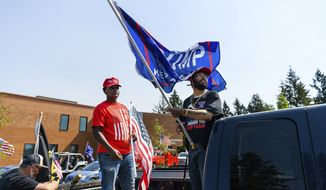 Friends Darrin Gantt, 20, left, and Stevan Garcia, 24, attend their second Trump rally at the &quot;Oregon for Trump 2020 Labor Day Cruise Rally&quot; at Clackamas Community College in Oregon City, Ore., Monday, Sept. 7, 2020. (AP Photo/Michael Arellano)