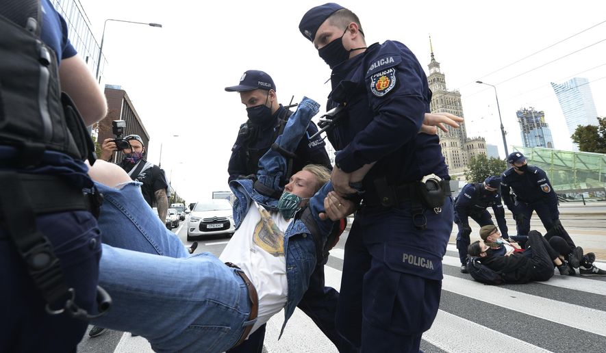 Polish police carry protesting environmentalists to the side to clear passage down one of Warsaw's main streets in Warsaw, Poland, Monday, Sept. 7, 2020. The Polish chapter of the international environmental group Extinction Rebellion blocked the street to spur the government into better protection of the environment, in a second such action in two days, in Warsaw. (AP Photo/Czarek Sokolowski)