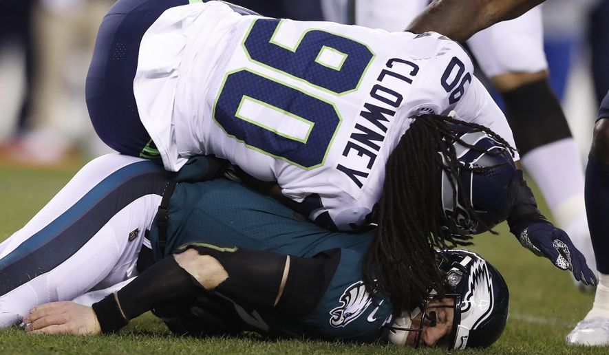 FILE - In this Jan. 5, 2020, file photo, Philadelphia Eagles&#39; Carson Wentz, bottom, is hit by Seattle Seahawks&#39; Jadeveon Clowney (90) during the first half of an NFL wild-card playoff football game in Philadelphia. The Tennessee Titans have agreed to terms with three-time Pro Bowl linebacker Clowney on a one-year contract. The Titans did not announce the terms Sunday, Sept. 6, 2020. (AP Photo/Julio Cortez, File)