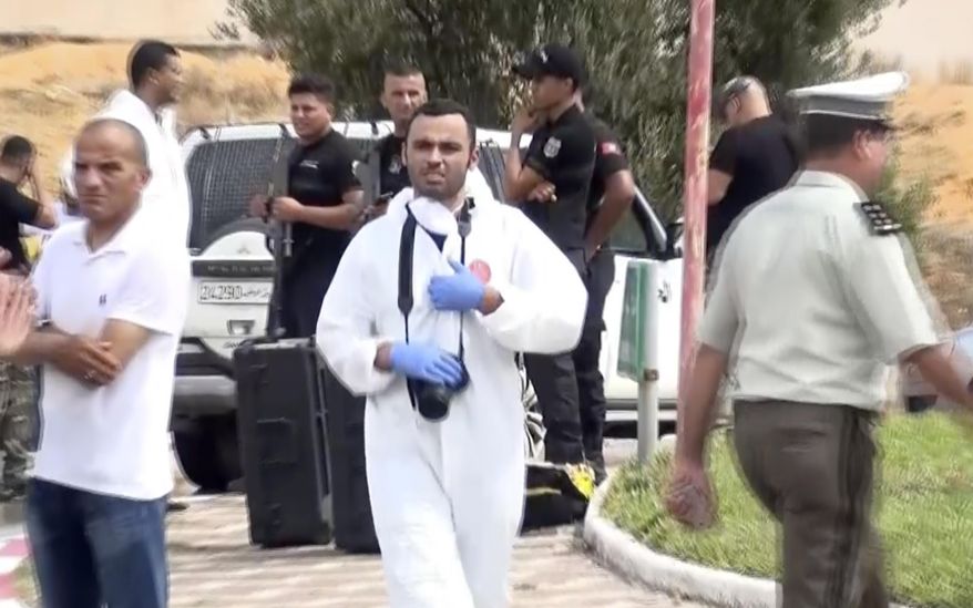 In this frame grab from a video, Tunisian police officers investigate after Tunisian forces shot dead three suspected Islamic militants who rammed their vehicle into security officers and attacked them with knives, killing one and injuring another in the coastal resort town of Sousse, eastern Tunisia, Sunday Sept.6, 2020. Speaking at the site of the attack, Tunisian prime minister Hicham Mechichi announced the arrest of a fourth suspect who had been aboard the vehicle that rammed the National Guard officers. (AP Photo/Mehdi El Arem)