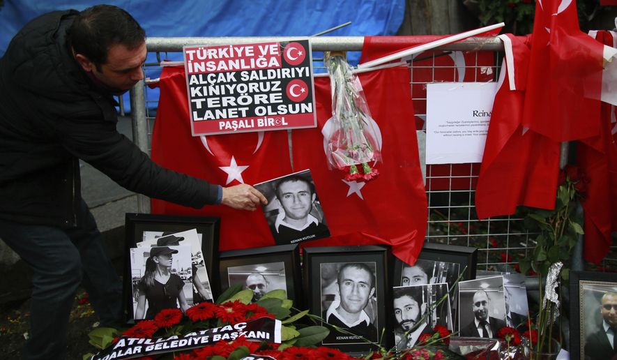 FILE - In this Wednesday, Jan. 4, 2017 file photo, a man adjusts a victim&#x27;s photograph displayed with floral tributes and Turkish flags, outside the Reina night club following the New Year&#x27;s day attack, in Istanbul. A Turkish court has on Monday, Sep. 7, 2020 sentenced an Islamic State militant to life in prison over the New Year’s Eve attack on a nightclub in Istanbul that left 39 people dead in 2017. Albulkadir Masharipov of Uzbekistan was charged with membership in a terror group, murder and attempting to overthrow the constitutional order, among other charges. (AP Photo/Emrah Gurel, file)