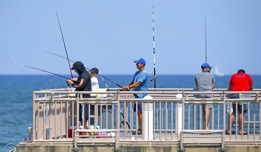People fishing at the Newport Fishing Pier in Sunny Isles Beach as the coronavirus pandemic continues on Sunday, Sept. 6, 2020. (David Santiago/Miami Herald via AP)