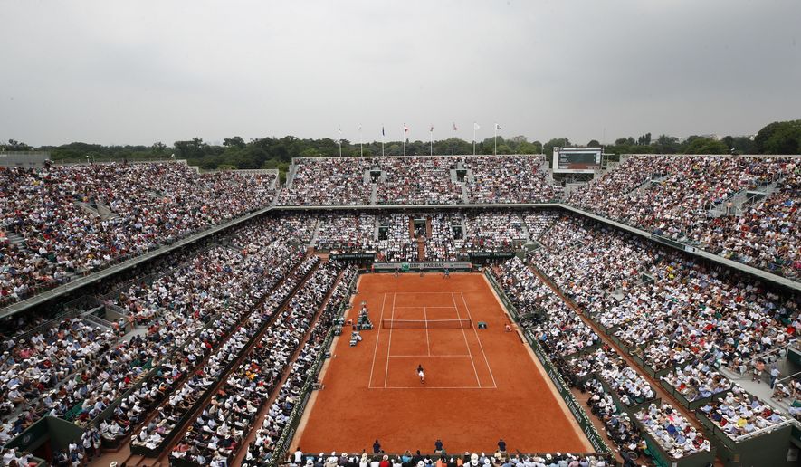 FILE - In this June 10, 2018 file photo, the crowd watch Austria's Dominic Thiem serving to Spain's Rafael Nadal during the men's final match of the French Open tennis tournament at the Roland Garros stadium,in Paris. Spectators will be allowed at the French Open later this month despite the growing number of coronavirus cases in the country, organizers said on Monday as they unveiled the health protocols for the clay-court Grand Slam tournament. The event will take place at Roland Garros stadium in western Paris from Sept. 27 after being postponed from its May date due to the pandemic. (AP Photo/Christophe Ena, File)