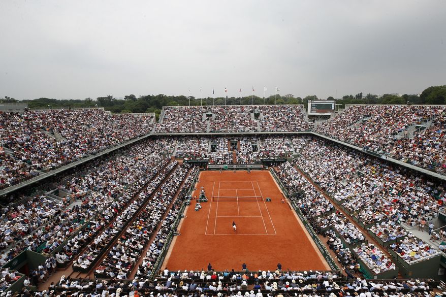 FILE - In this June 10, 2018 file photo, the crowd watch Austria's Dominic Thiem serving to Spain's Rafael Nadal during the men's final match of the French Open tennis tournament at the Roland Garros stadium,in Paris. Spectators will be allowed at the French Open later this month despite the growing number of coronavirus cases in the country, organizers said on Monday as they unveiled the health protocols for the clay-court Grand Slam tournament. The event will take place at Roland Garros stadium in western Paris from Sept. 27 after being postponed from its May date due to the pandemic. (AP Photo/Christophe Ena, File)