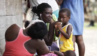 Women and children sit idle at a migrant camp amid the new coronavirus pandemic in Lajas Blancas, Darien province, Panama, Saturday, Aug. 29, 2020. In Lajas Blancas, the migrants did not wear masks or practice social distancing, but Panama&#39;s Public Security Minister Juan Pino said there have not been more than 10 infections among the migrants. (AP Photo/Arnulfo Franco) **FILE**