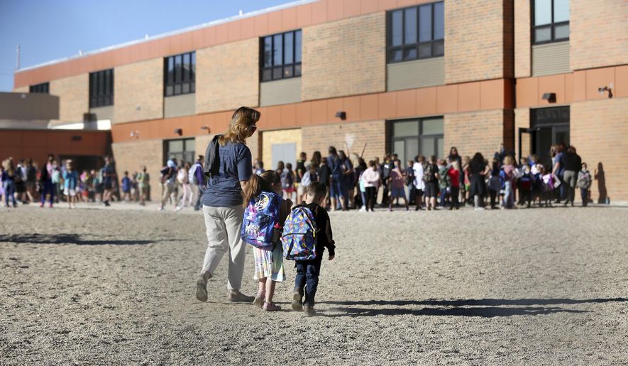 Teachers at Park Elementary School in Casper, Wyo., lead students by grade in to the school while following new health guidelines, Wednesday, Sept. 2, 2020. (Cayla Nimmo/The Casper Star-Tribune via AP)