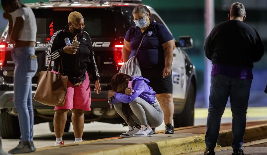 A woman kneels on the ground outside the University of Chicago Medicine&#39;s Comer Children&#39;s Hospital where a 8-year-old girl was taken after being killed in a shooting that wounded three others near the intersection of 47th street and Union Avenue during the Labor Day weekend, Monday Sep. 7, 2020 in Chicago. (Armando L. Sanchez/Chicago Tribune via AP)