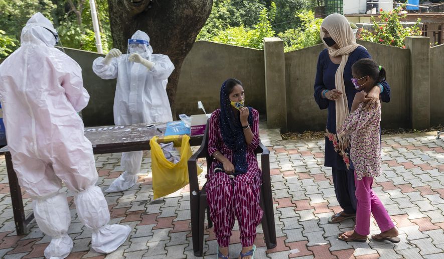 A woman and her daughter wait as their relative sits for a COVID-19 test at a rural health centre in Bagli, outskirts of Dharmsala, India, Monday, Sept. 7, 2020. India&#39;s coronavirus cases are now the second-highest in the world and only behind the United States. (AP Photo/Ashwini Bhatia)