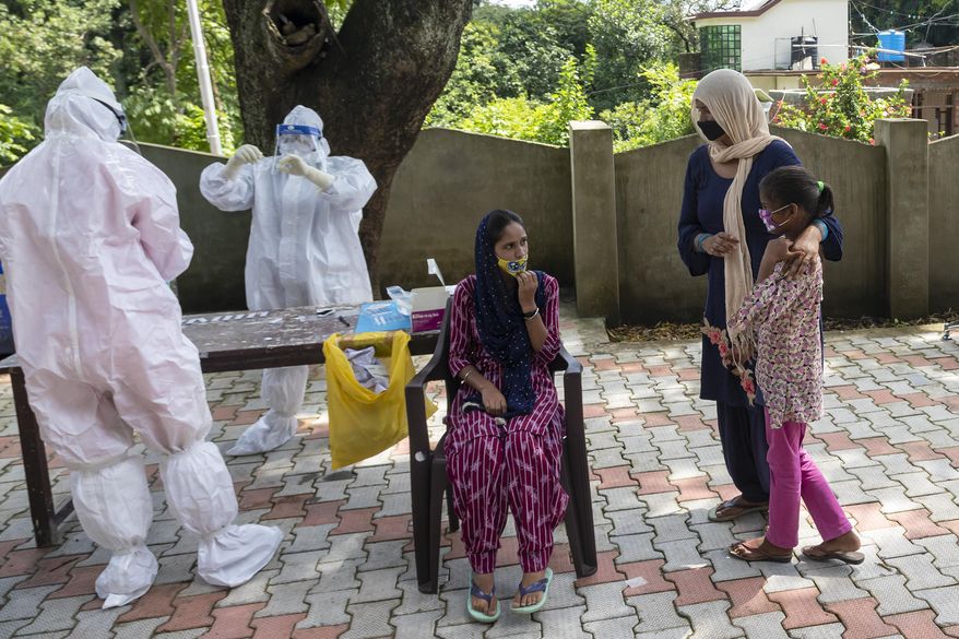 A woman and her daughter wait as their relative sits for a COVID-19 test at a rural health centre in Bagli, outskirts of Dharmsala, India, Monday, Sept. 7, 2020. India&#39;s coronavirus cases are now the second-highest in the world and only behind the United States. (AP Photo/Ashwini Bhatia)