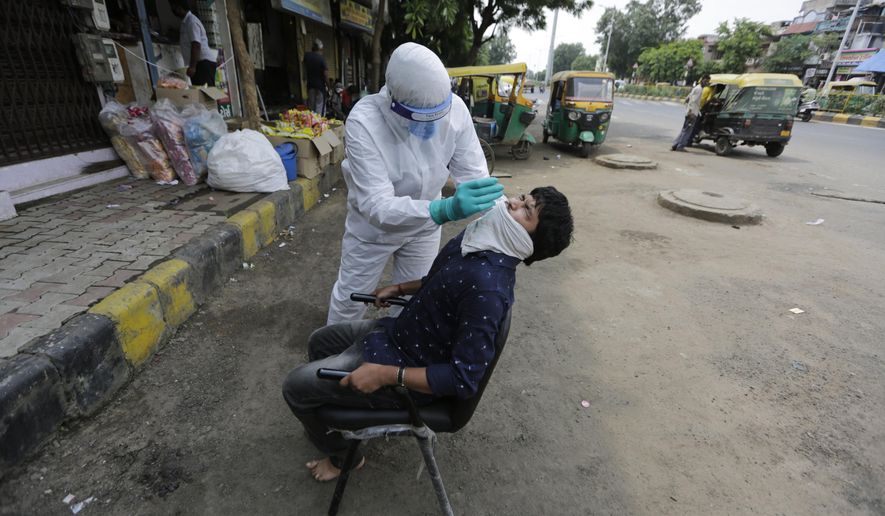 A health worker takes a nasal swab sample to test for COVID-19 in Ahmedabad, India, Tuesday, Sept. 8, 2020. India's coronavirus cases are now the second-highest in the world and only behind the United States. (AP Photo/Ajit Solanki)